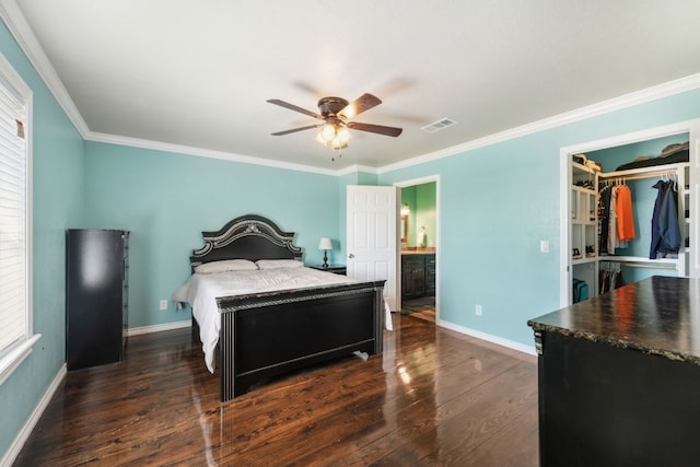 bedroom featuring ceiling fan, a closet, crown molding, a spacious closet, and dark hardwood / wood-style flooring