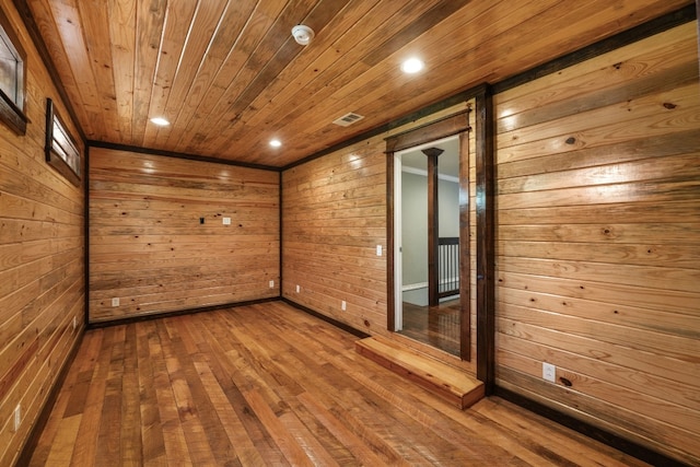 empty room featuring wood ceiling, wood walls, ornate columns, and dark hardwood / wood-style flooring