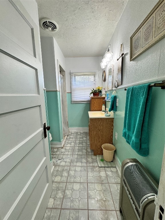 bathroom featuring walk in shower, a textured ceiling, vanity, and tile flooring