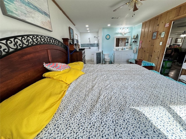 bedroom featuring crown molding, ceiling fan, wooden walls, and ensuite bathroom