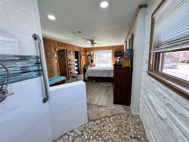 tiled bedroom with wooden walls and ceiling fan