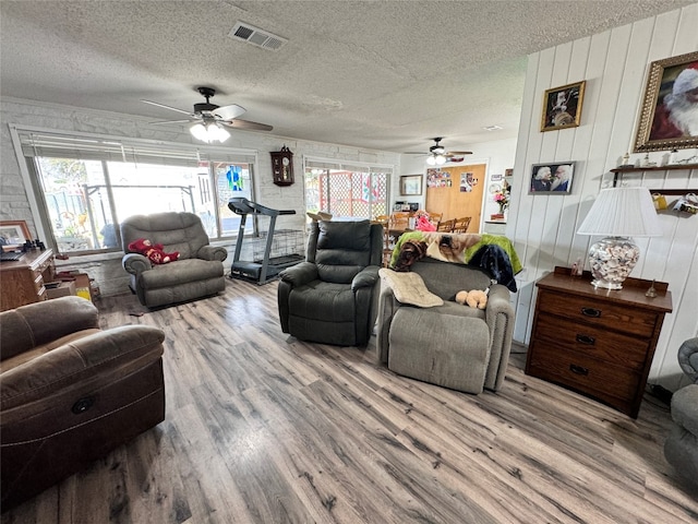 living room featuring a textured ceiling, ceiling fan, and hardwood / wood-style flooring