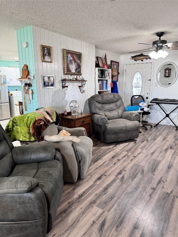 living room with ceiling fan, a textured ceiling, and dark hardwood / wood-style floors