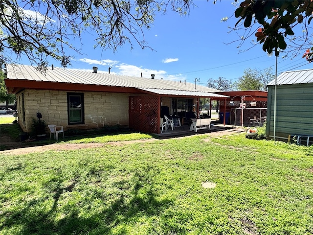 rear view of house with a lawn and a patio