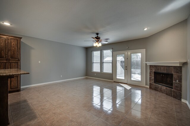 tiled living room featuring a tiled fireplace and ceiling fan