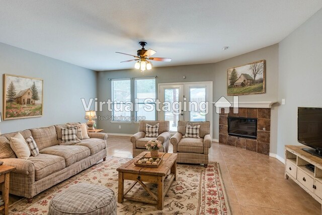 unfurnished living room featuring ceiling fan, french doors, light tile patterned floors, and a tiled fireplace