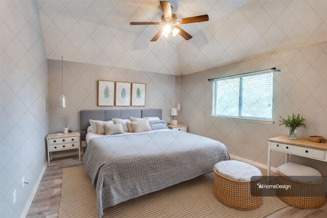 empty room with vaulted ceiling, ceiling fan, and hardwood / wood-style floors