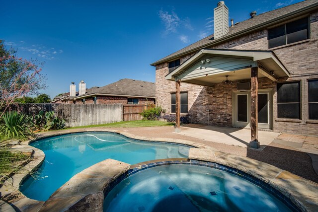 view of swimming pool with an in ground hot tub and a storage shed