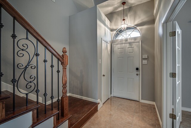 tiled empty room featuring lofted ceiling, french doors, and an inviting chandelier