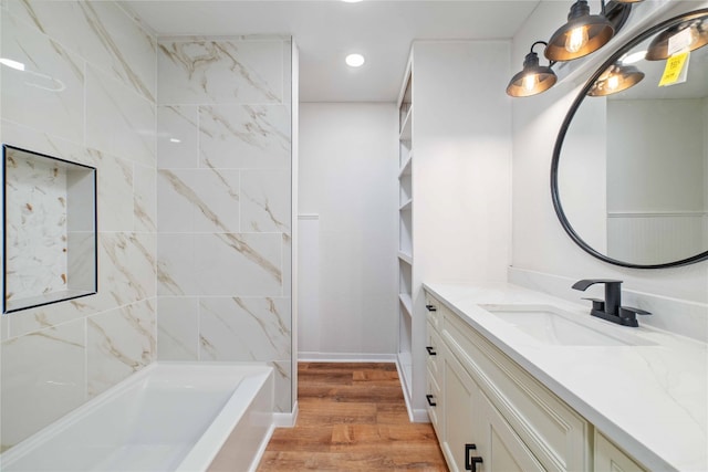 bathroom with wood-type flooring, vanity, and tiled shower / bath combo