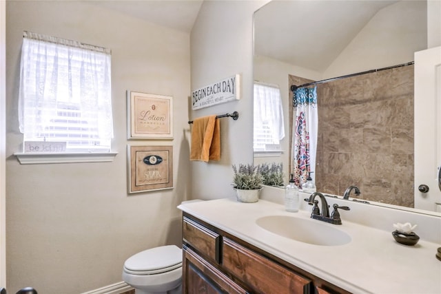 bathroom with toilet, vanity with extensive cabinet space, and a wealth of natural light