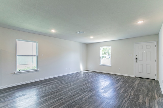 unfurnished room with dark wood-type flooring and a textured ceiling