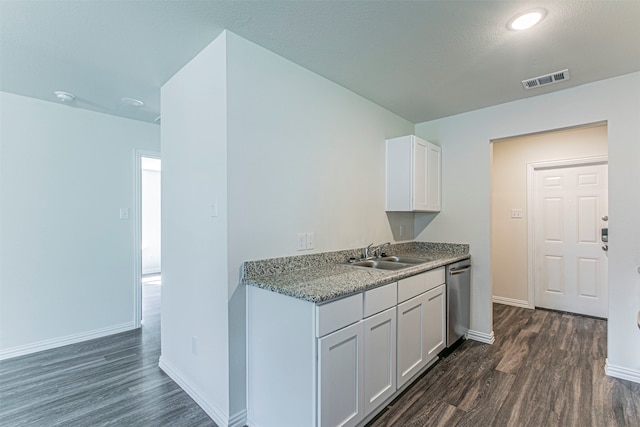 kitchen featuring white cabinetry, dishwasher, dark hardwood / wood-style floors, stone counters, and sink