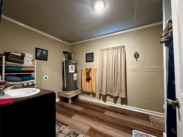 bathroom featuring ornamental molding, vanity, hardwood / wood-style floors, and water heater