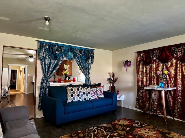 living room with ceiling fan and a textured ceiling