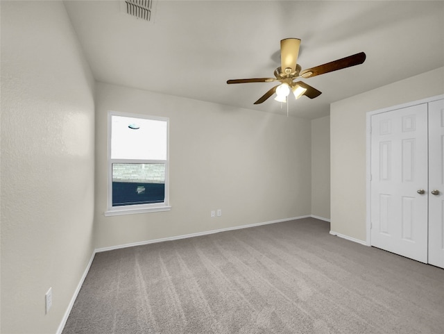 unfurnished room with light colored carpet and ceiling fan