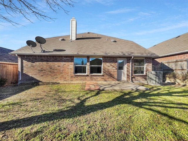 rear view of house with a patio and a lawn