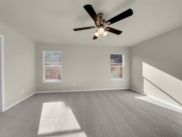 spare room featuring light colored carpet, ceiling fan, and a healthy amount of sunlight