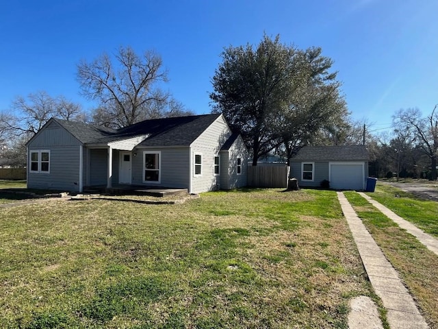 view of front of home featuring a front yard, an outdoor structure, and a garage