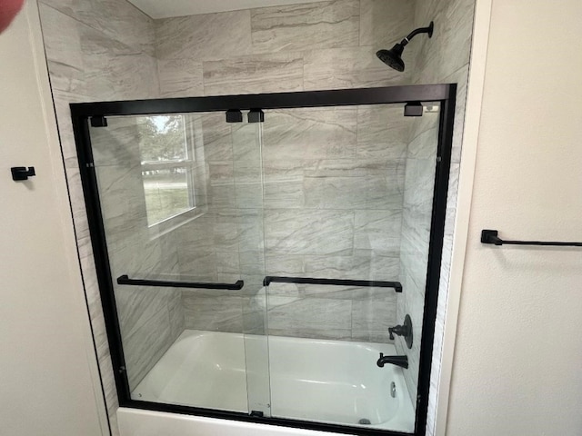 bathroom with shower / bath combination with glass door