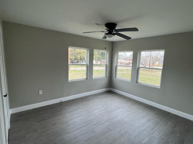 spare room with plenty of natural light, ceiling fan, and dark hardwood / wood-style floors