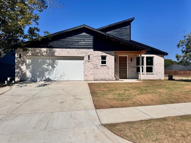 view of front of home with a garage and a front lawn