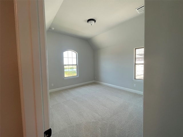 interior space featuring light colored carpet and vaulted ceiling