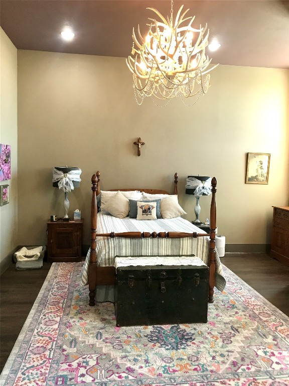 bedroom with dark hardwood / wood-style floors and a notable chandelier