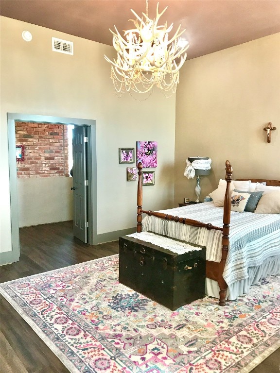 bedroom featuring dark hardwood / wood-style flooring and a notable chandelier