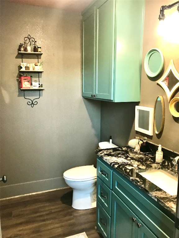 bathroom with hardwood / wood-style floors, large vanity, and toilet