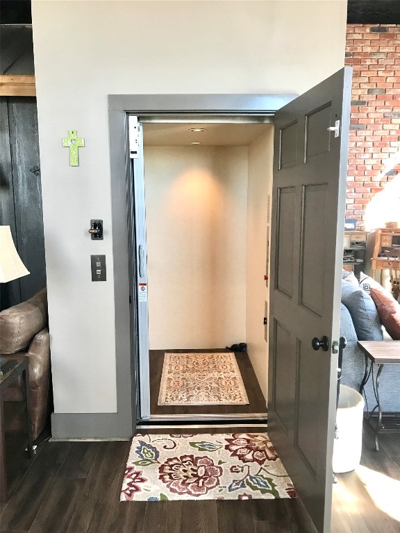 doorway to outside featuring dark hardwood / wood-style floors and elevator