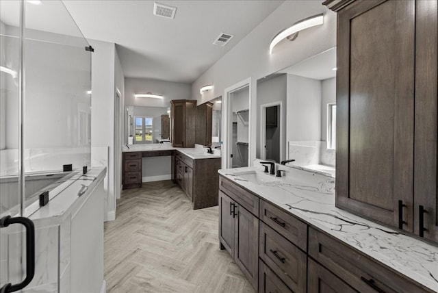 bathroom featuring dual bowl vanity and parquet floors