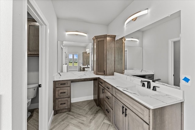 bathroom featuring parquet flooring, vanity, and toilet