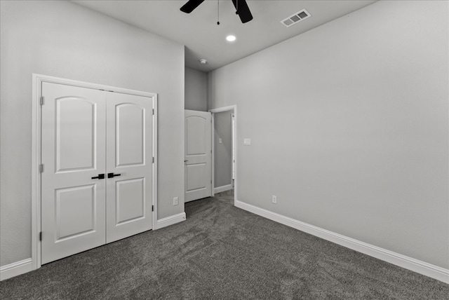 unfurnished bedroom featuring a closet, ceiling fan, and dark colored carpet