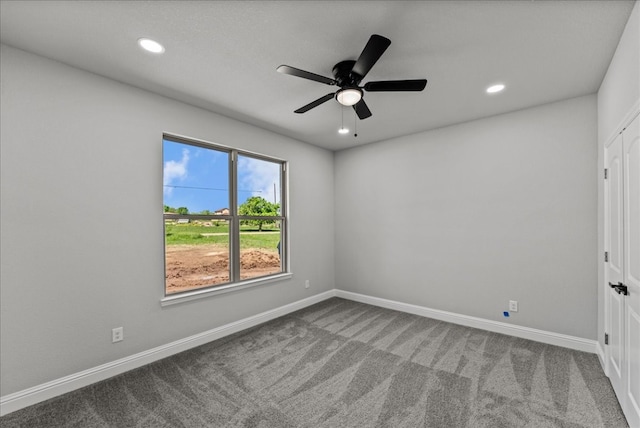 carpeted spare room with ceiling fan