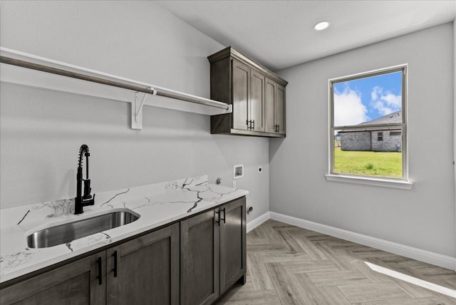 washroom featuring light parquet floors, hookup for an electric dryer, cabinets, washer hookup, and sink