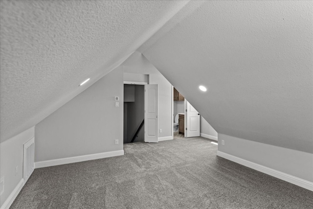 additional living space featuring light carpet, a textured ceiling, and lofted ceiling