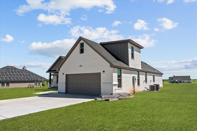 view of front facade featuring a garage, central AC unit, and a front lawn