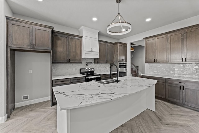 kitchen featuring light stone countertops, stainless steel appliances, a center island with sink, light parquet flooring, and sink