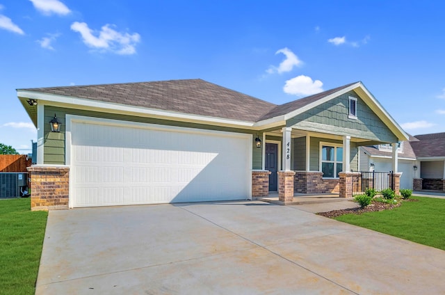 craftsman-style house with a garage, central AC, a front lawn, and covered porch