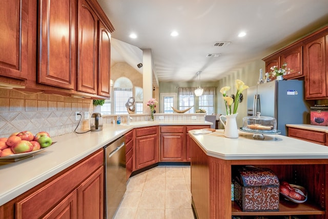 kitchen with light tile patterned flooring, hanging light fixtures, appliances with stainless steel finishes, a kitchen island, and decorative backsplash