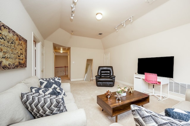 carpeted living room with vaulted ceiling and track lighting