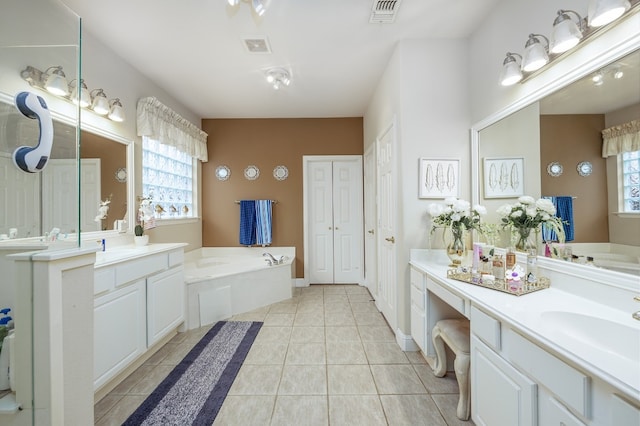 bathroom featuring tile patterned flooring, vanity, and a bath