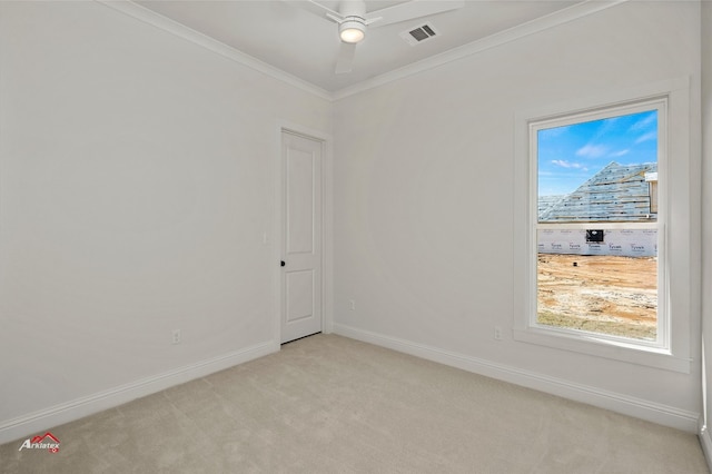 spare room with ceiling fan, ornamental molding, and light carpet