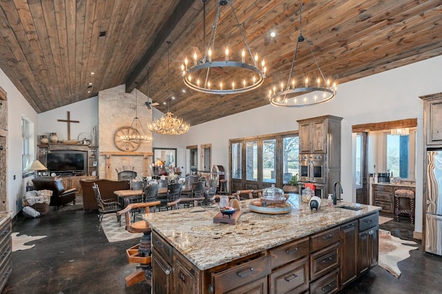 kitchen featuring stainless steel appliances, sink, wood ceiling, a chandelier, and a kitchen island with sink