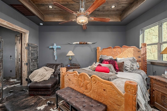 bedroom with ceiling fan, wood ceiling, and a tray ceiling