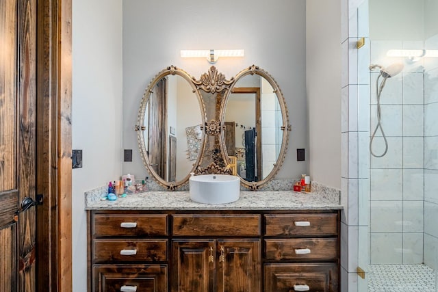 bathroom featuring a tile shower and vanity