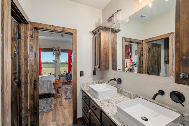 bathroom featuring dual sinks, oversized vanity, and hardwood / wood-style flooring