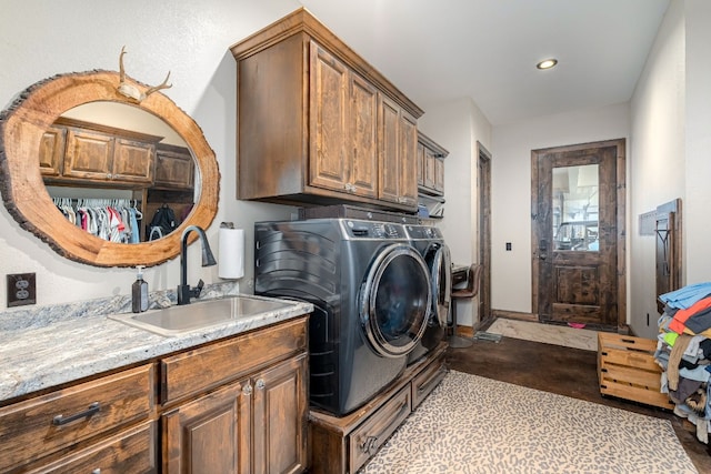 clothes washing area with sink, cabinets, and washing machine and clothes dryer