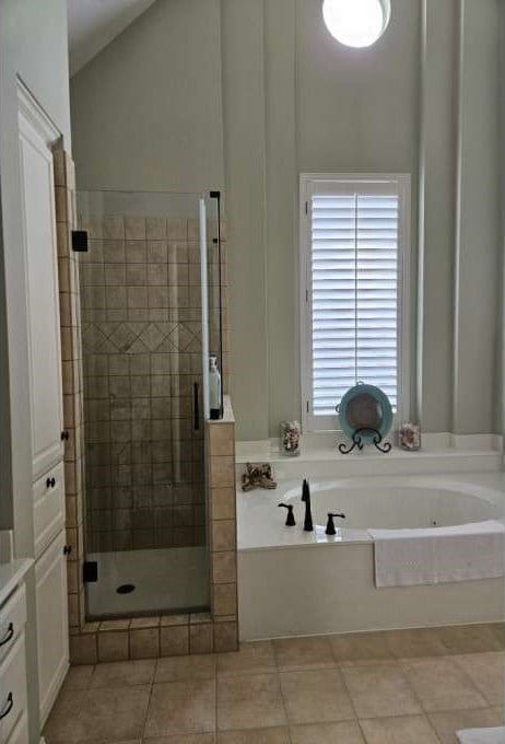 bathroom featuring vanity, tile flooring, lofted ceiling, and plus walk in shower